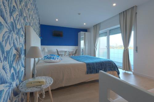 1 dormitorio con 1 cama con pared azul en Curia Clube en Curia