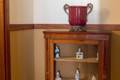 a red vase sitting on top of a wooden shelf at Quinta Sta Luzia Carrascal in Vila Flor
