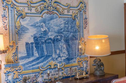 a tapestry hanging on a wall with a lamp at Quinta Sta Luzia Carrascal in Vila Flor