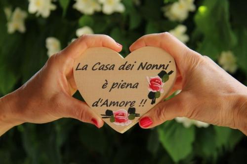 TassulloにあるLa casa dei nonniの花の心を持つ一対の手