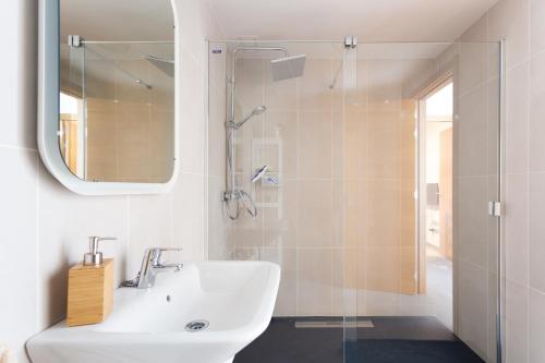 La TejitaにあるLa Tejita Luxury Apartmentの白いバスルーム(シンク、シャワー付)