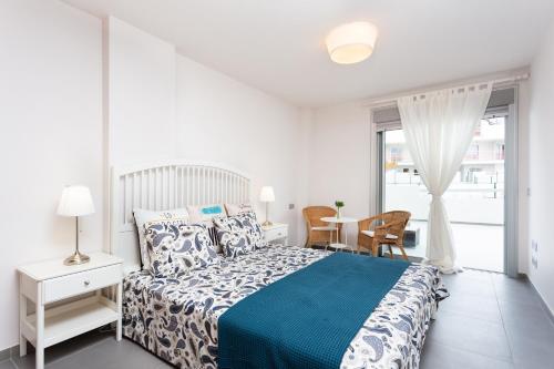 La TejitaにあるLa Tejita Luxury Apartmentのベッドルーム1室(ベッド1台、テーブル、椅子付)