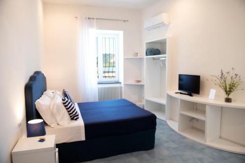 a small room with a bed and a desk at Domus Fortunae B&B in Bacoli