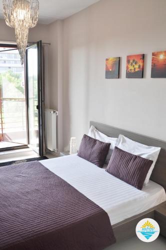 a bedroom with a large bed with purple pillows at Antos Deluxe Apartment in Constanţa