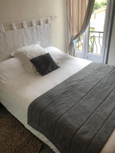 a large bed with a black pillow on it at Central Hotel in Niort