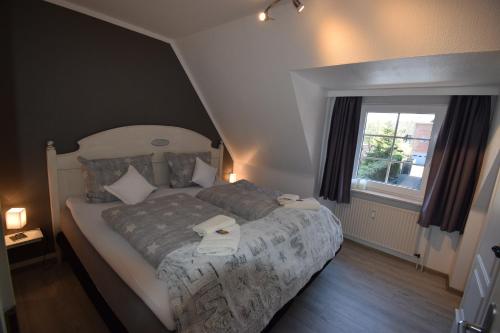 a bedroom with a bed with two towels on it at An de Warft Appartement 10 Schatz am Deich in Büsum