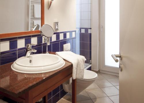 a bathroom with a sink and a toilet and a mirror at BIO-Hotel Villa Orange in Frankfurt/Main