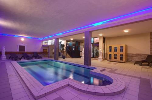 una piscina in una casa con luci viola di Canifor Hotel a San Pawl il-Baħar