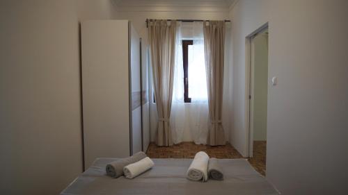 ein Schlafzimmer mit einem Bett mit zwei Kissen und einem Fenster in der Unterkunft Apartmani Laura in Trogir