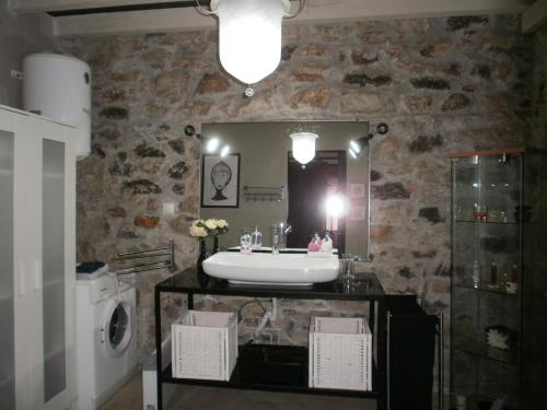 a bathroom with a sink and a washing machine at Joanna in Stavroupoli