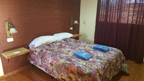 Una habitación de hotel con una cama con dos bolsas. en Cabañas del Gallego en San Rafael