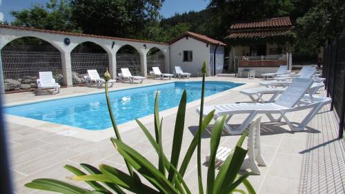 une piscine avec des chaises longues et une piscine dans l'établissement Le Verger des Ascarines, à Corneilla-de-Conflent