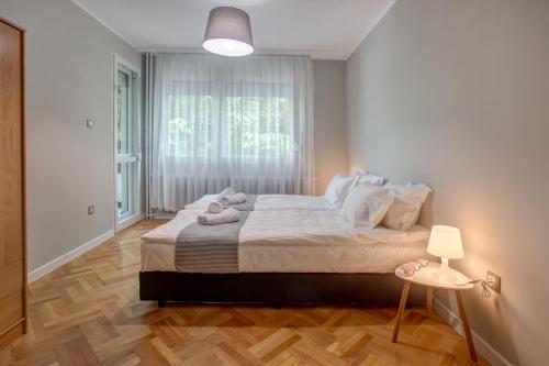 Un dormitorio con una cama grande y una ventana en Spacious flat close to the American Embassy, en Sofía