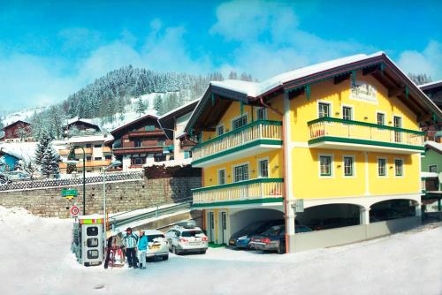 a group of people standing in the snow in front of a building at Schlosserhaus Appartements in Wagrain