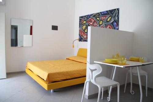 una piccola camera con letto e tavolo di Iride Guest House a Oristano