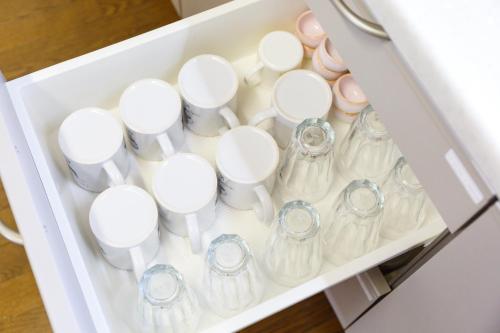 a drawer filled with white cups and vases at Mon Petit Chat in Kanazawa