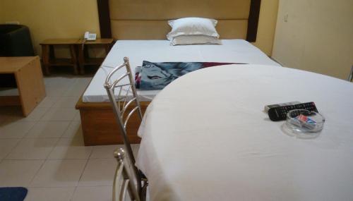 uma cama num quarto de hospital com uma colcha branca em Royal Park Residential Hotel em Chittagong