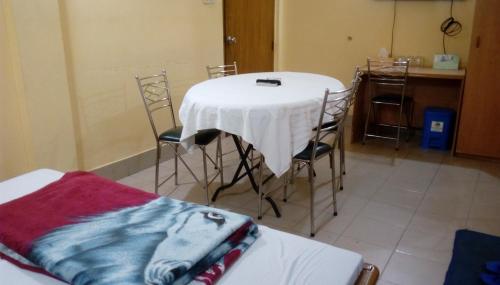 uma mesa num quarto com cadeiras e uma mesa com uma toalha de mesa branca em Royal Park Residential Hotel em Chittagong