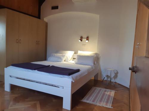 sypialnia z białym łóżkiem z białą pościelą i poduszkami w obiekcie Apartment Nada w mieście Opatija