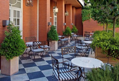 um pátio exterior com mesas, cadeiras e plantas em Valladolid Recoletos em Valladolid