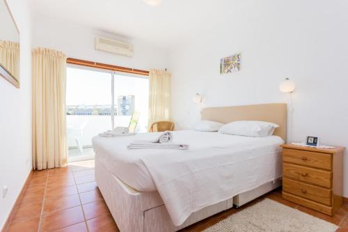 a bedroom with a large white bed and a window at Casa Harland by Seewest in Albardeira