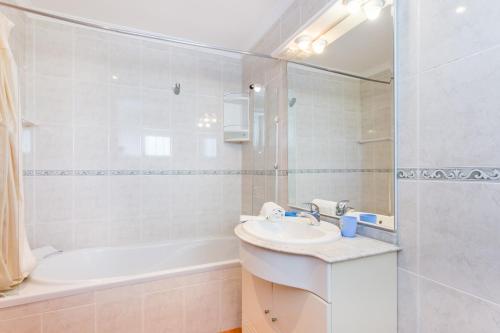 a bathroom with a sink and a tub and a toilet at Casa Harland by Seewest in Albardeira