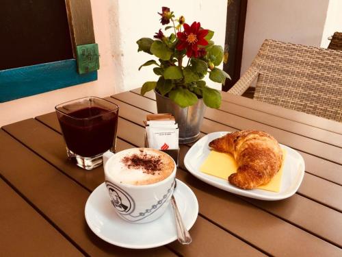 Albergo Il Brillantino في سان نيكولا أرسيلا: طاولة مع كوب من القهوة وصحن من الطعام