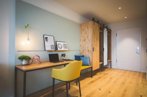 an office with a desk and a yellow chair at Hotel Federwerk in Sankt Georgen im Schwarzwald