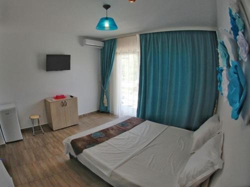 ein Schlafzimmer mit einem Bett und einem blauen Vorhang in der Unterkunft Vila Maria in Eforie Nord