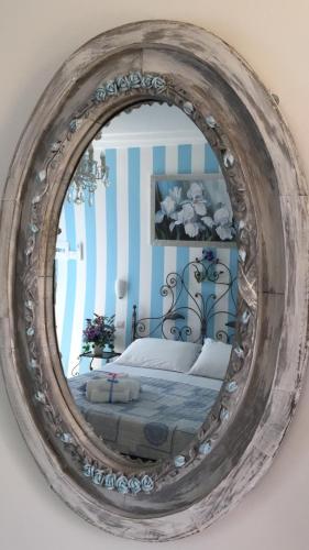 a mirror on a wall with a bed in a room at Giglio Del Conero in Numana