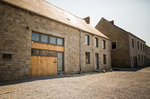- un bâtiment en briques avec une porte en bois dans l'établissement Gîtes du tellin, à Couvin
