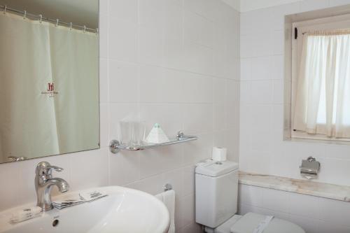 a bathroom with a sink and a toilet and a mirror at Hotel do Lago in Braga