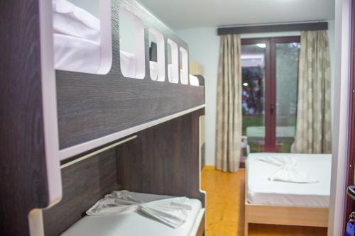 a room with two bunk beds and a window at Delight Beach Hotel in Dhërmi