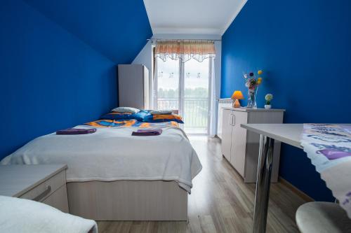 ユルグフにあるNoclegi u Bernadkówの青いベッドルーム(ベッド1台、テーブル付)