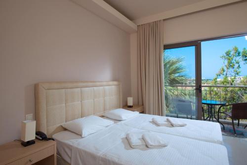 Een bed of bedden in een kamer bij Oasis Beach Hotel - Adults Only