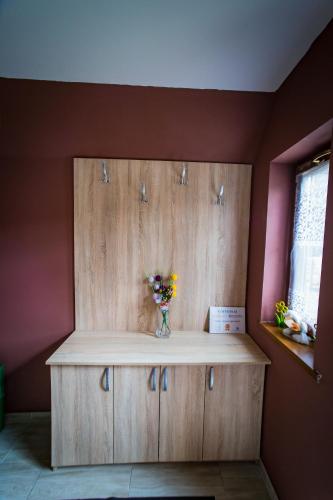 a wooden cabinet with a vase of flowers on it at Noclegi u Bernadków in Jurgów