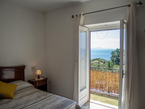 a bedroom with a bed and a sliding glass door at Casa Il Negrito in Massa Lubrense