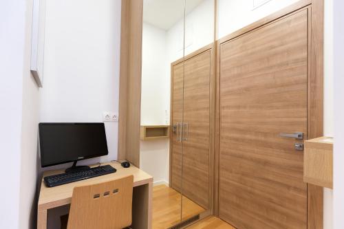 a room with a desk with a computer and a door at Dream Hotel in Velika Gorica