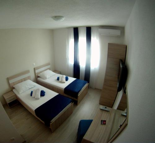 a small room with two beds and a mirror at Pansion Nerry in Blagaj