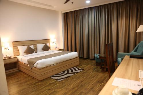 a hotel room with a bed and a chair at Ana Clarks Inn, Panchkula in Panchkula