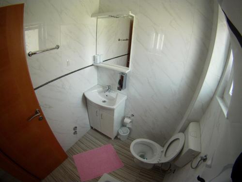 a small bathroom with a toilet and a sink at Pansion Nerry in Blagaj