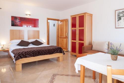 a bedroom with a bed and a table in it at Casa Viter Zaostrog in Zaostrog