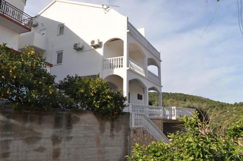 a white house with a staircase leading up to it at Apartments Zora in Vis