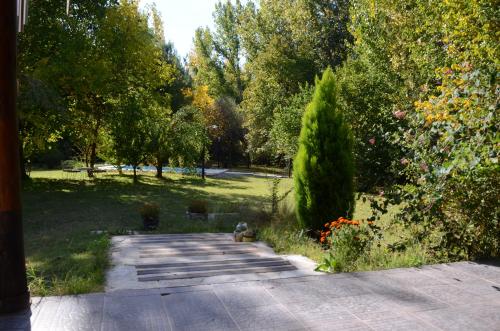 einen Garten mit einem Gehweg sowie Bäumen und Sträuchern in der Unterkunft Casa de campo de piedra in Tunuyán