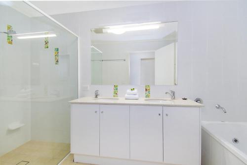 a white bathroom with a sink and a shower at Lennox on the Beach Unit 2 - Lennox Head in Lennox Head