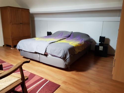 a bedroom with a bed and a wooden floor at De Boerebeemd in Lieshout