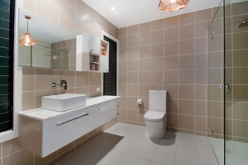 a bathroom with a toilet and a sink and a shower at Pandanus - Lennox Head in Lennox Head