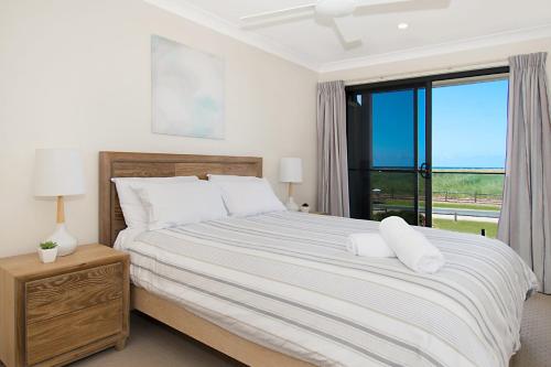 a bedroom with a large bed with a window at Sunrise Reef 4 in Lennox Head