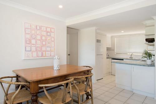 a kitchen with a wooden table and some chairs at Sunrise Reef 4 in Lennox Head