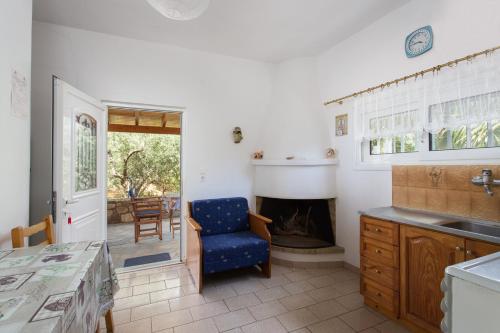 a kitchen with a fireplace and a blue chair at Ta Ambelakia in Monemvasia
